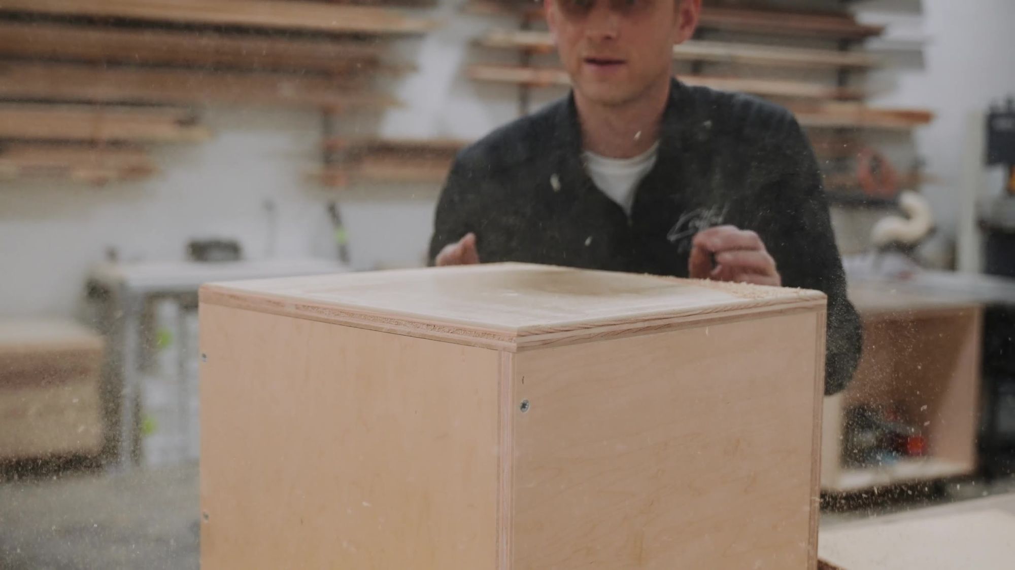 A cabinet box on the bench in a cloud of sawdust