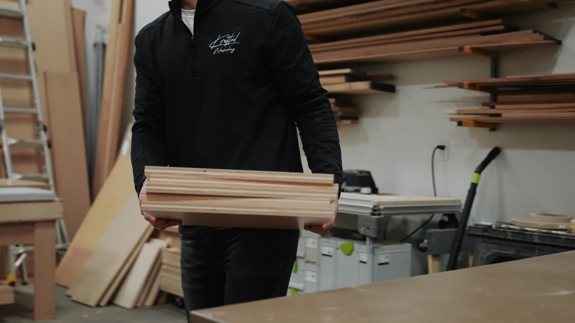 Carrying a stack of cut boards across the shop