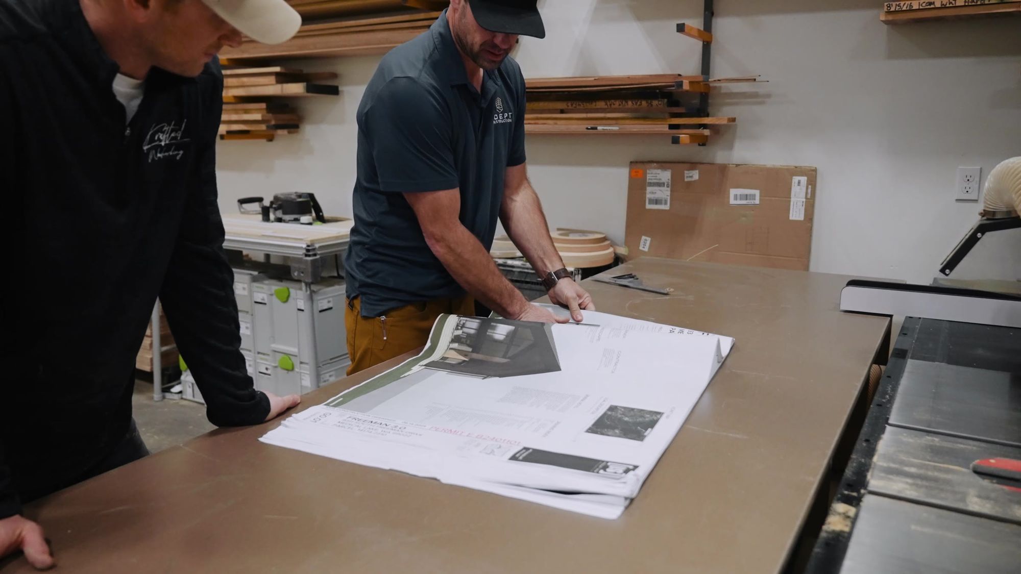 Reviewing drawings spread across the bench